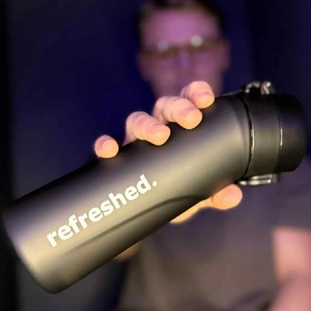 Mann som holder frem en refreshed Classic flaske